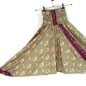 Puede incluir: Pantalones de pierna ancha con estampado amarillo, azul y rojo y cintura elástica. Los pantalones tienen una silueta amplia y fluida.