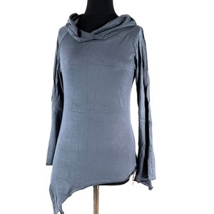 May include: A slate blue long-sleeve top with a cowl neck and an asymmetrical hemline. The top is displayed on a mannequin and has a relaxed fit. The sleeves are long and slightly flared. The fabric appears to be soft and flowing.