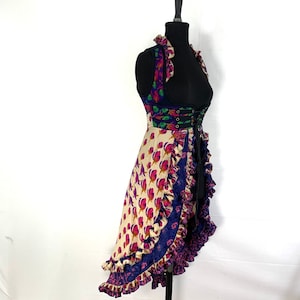 May include: A multi-colored, floral print, high-low, sleeveless vest with a lace-up front and a ruffled hem.