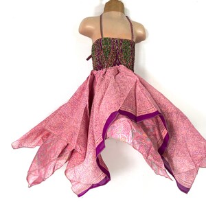 May include: A pink and purple floral print dress with a halter top and a flowing skirt. The dress is made of a lightweight fabric and has a bohemian style.