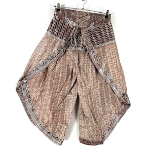 May include: Wide-leg pants with a unique design. The pants feature a beige floral pattern with burgundy and silver accents. The waistband has a burgundy pattern and a lace-up closure. The pants are hanging on a metal hanger.