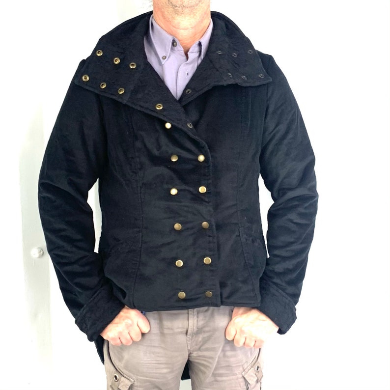 May include: A black jacket with a high collar and gold buttons. The collar has decorative studs.