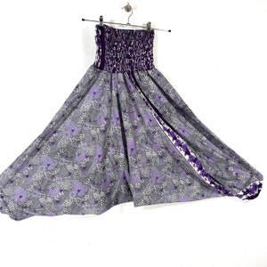 May include: Purple and gray patterned pants with a wide leg and elastic waistband. The pants have a floral print on the side.
