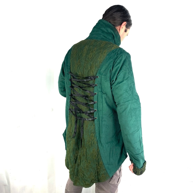 May include: A green jacket with a lace-up back detail. The jacket has a high collar and long sleeves.