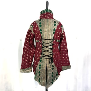 May include: A red and green quilted jacket with a lace-up back. The jacket has a high collar and long sleeves. The fabric is patterned with gold accents.
