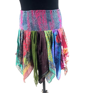 Puede incluir: Falda bohemia colorida con cintura elástica estampada en tonos rosas y azules. La falda presenta un diseño patchwork de varias telas estampadas en rojo, verde, morado y azul, creando un look único y vibrante.