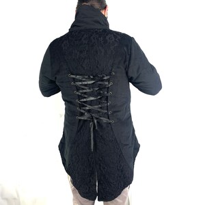May include: Black long-sleeved jacket with a lace pattern and a lace-up back. The jacket has a high collar and a long tail.