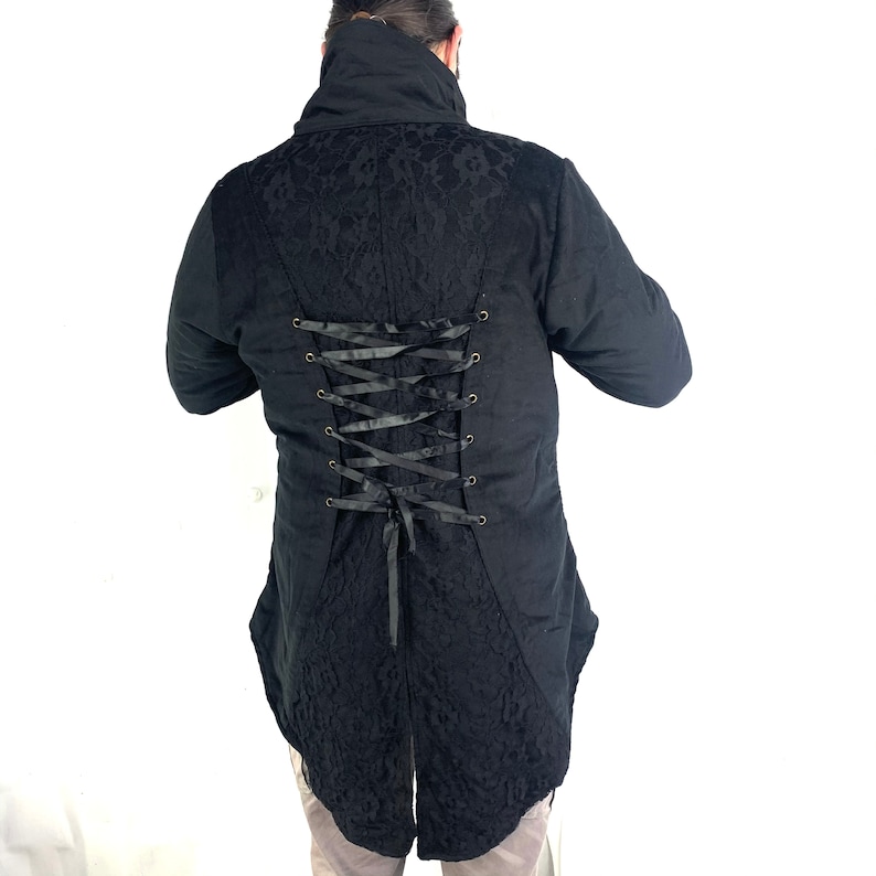 May include: Black long-sleeved jacket with a lace pattern and a lace-up back. The jacket has a high collar and a long tail.