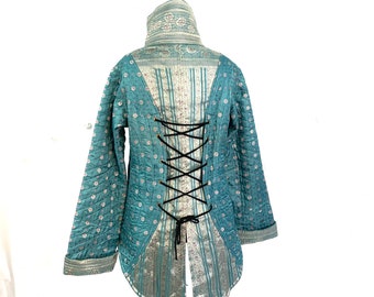 L. Silk Brocade Tailcoat. Fleece lined with brass poppers and pockets. Corsetage at back for adjustable sizing.