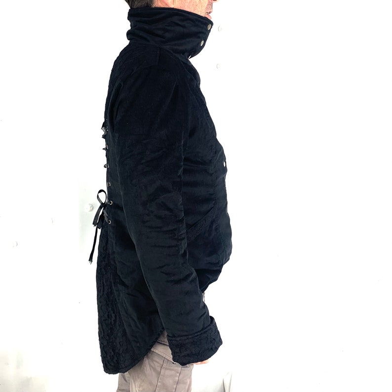 May include: Black quilted jacket with a high collar and a lace-up detail in the back.