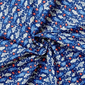 May include: A navy blue fabric with a repeating pattern of white and blue fish, red seashells, and small white stars. The fish vary in size and design, creating a nautical theme. The fabric is likely cotton or a similar material.