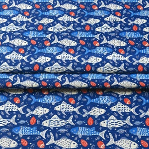 May include: A blue fabric with a repeating pattern of white and blue fish, red seashells, and fish bones. The fish are stylized with detailed scales and fins. The background is a solid, deep blue color.