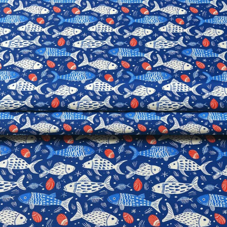 May include: A blue fabric with a repeating pattern of white and blue fish, red seashells, and fish bones. The fish are stylized with detailed scales and fins. The background is a solid, deep blue color.