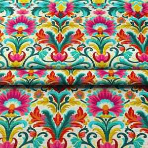 Könnte beinhalten: Ein lebendiger floraler Stoff mit einem sich wiederholenden Muster aus großen rosa Blüten, türkisfarbenen Blättern und orangefarbenen Akzenten auf cremefarbenem Hintergrund. Das Design umfasst gelbe und grüne Details und schafft einen farbenfrohen und verzierten Textil.