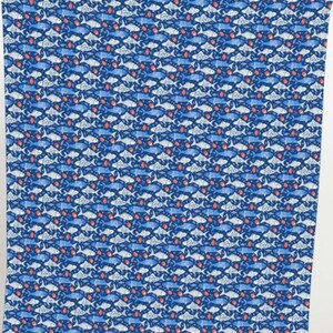 May include: A blue fabric with a repeating pattern of fish in shades of blue and white, interspersed with small red shapes. The fish are stylized and arranged in a grid-like formation, creating a visually dense and textured design.