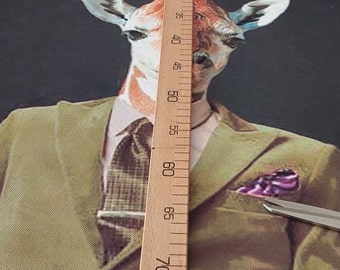 May include: A canvas print featuring a giraffe wearing a green blazer, a patterned tie, and a pocket square. The giraffe's head is centered, with a wooden ruler placed vertically in front of it. The background is dark.