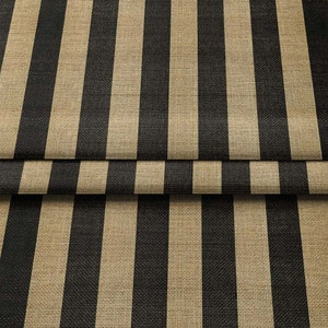 Può includere: Primo piano di un tessuto a righe verticali nere e beige. Il tessuto ha una trama tessuta, con le righe che corrono per tutta la lunghezza del materiale. Il tessuto è ripiegato in basso, mostrando la continuità del motivo.