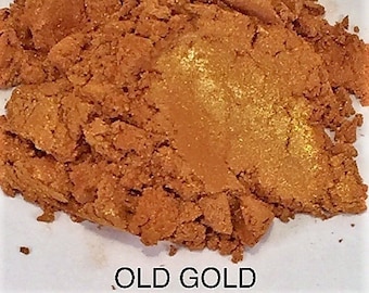 May include: A close-up of a pile of loose, fine, metallic pigment powder in a warm, golden brown color with a hint of gold shimmer. The powder is labeled "OLD GOLD".