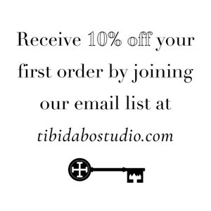 May include: Text graphic that reads "Receive 10% off your first order by joining our email list at tibidabostudio.com". A black and white illustration of a key with a cross on the knob.