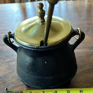 Vintage Cast Iron Fire Starter with pumice wand and brass lid. Three cast iron legs. Smudge pot cauldron 6” wide, 7” tall.