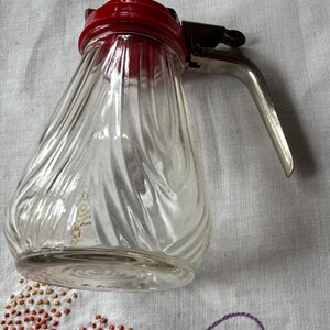 Vintage 5 ”Glassirupkrug mit rotem Plastikdeckel und versenkbarem Metallauslauf.