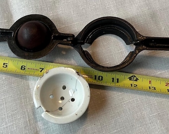 Vintage gietijzeren citroenpers met porseleinen kern