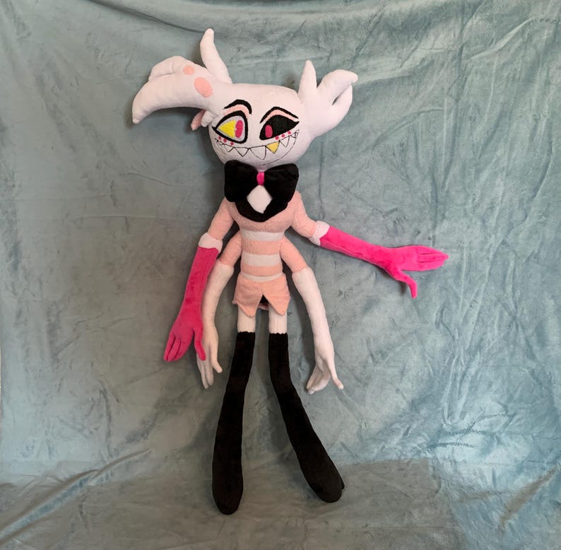 May include: A plush toy of a character with white fur, pink and white striped clothing, black boots, and pink and white arms. The character has a black bow tie and red eyes with yellow pupils.
