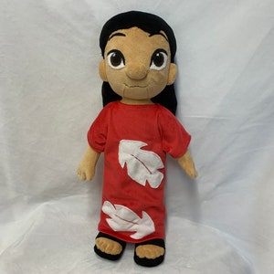 May include: A plush doll of Lilo from the Disney movie Lilo & Stitch. The doll is wearing a red dress with white leaf designs and has black hair.