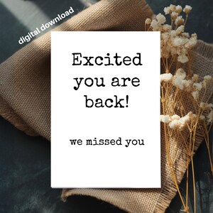 May include: A white rectangular greeting card featuring the black typewriter-style text "Excited you are back!" and "we missed you" in the centre. The card includes the text "digital download" in the upper left corner of the image.