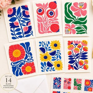 Peut inclure: Un ensemble de 14 cartes de correspondance vierges et enveloppes. Les cartes présentent des motifs floraux colorés en bleu, rose, rouge et jaune. L'ensemble comprend divers motifs floraux, avec des autocollants assortis. Le texte "SET OF 14 BLANK NOTECARDS & ENVELOPES" est visible.