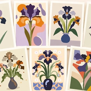 May include: A set of greeting cards featuring stylized iris flower illustrations in shades of purple, orange, and green. The cards have a cream-colored background and are arranged in a grid. The text "14 CARDS 14 ENVELOPES" is visible.