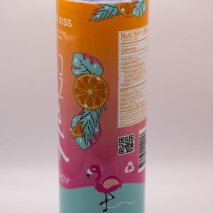 May include: A stainless steel tumbler with a tropical design. The tumbler features a gradient of orange, pink, and teal, with illustrations of oranges, palm leaves, and a flamingo. The text "ZOZ ENERGY" is visible.