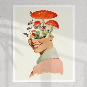 May include: A woman's face is replaced with a cluster of red and white mushrooms growing from a green patch of grass. The mushrooms are arranged in a way that resembles a crown. The woman is smiling and wearing a pink shirt.