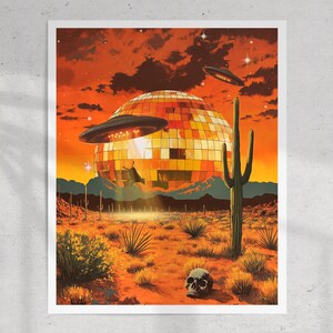 May include: A large, gold disco ball sits in a desert landscape with a UFO hovering above it. The sky is a vibrant orange with a few stars visible. A tall cactus stands in the foreground, and a human skull lies on the ground.