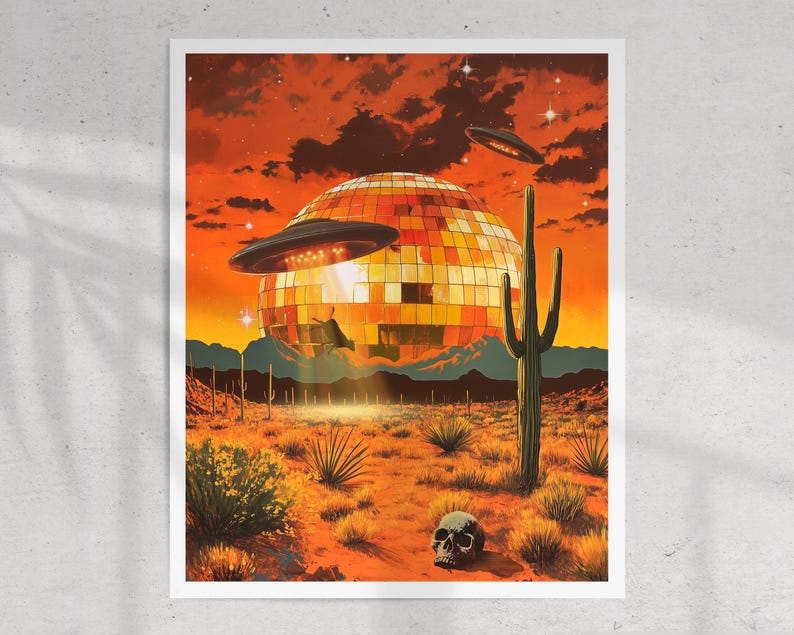May include: A large, gold disco ball sits in a desert landscape with a UFO hovering above it. The sky is a vibrant orange with a few stars visible. A tall cactus stands in the foreground, and a human skull lies on the ground.