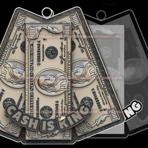 May include: A silver-colored metal pendant shaped like three stacked $100 bills. The bills have a raised 3D design and the text "CASH IS KING" is embossed on the bottom bill.