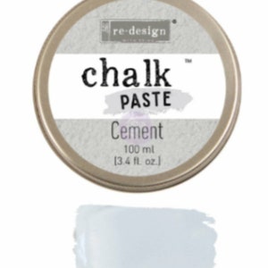May include: A round metal tin of re-design chalk paste in the color Cement. The tin is 3.4 fluid ounces or 100 milliliters. The tin is on a white background.