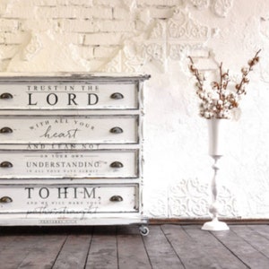 May include: White dresser with four drawers featuring a religious quote: "Trust in the Lord with all your heart and lean not on your own understanding. To Him."