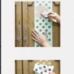 Peut inclure: Gros plan sur une porte de placard en bois en cours de d&eacute;coration avec un pochoir &agrave; pois turquoise et blanc. Le pochoir est appliqu&eacute; sur la porte par sections, et la personne utilise un pinceau pour appliquer de la peinture dor&eacute;e &agrave; travers le pochoir.