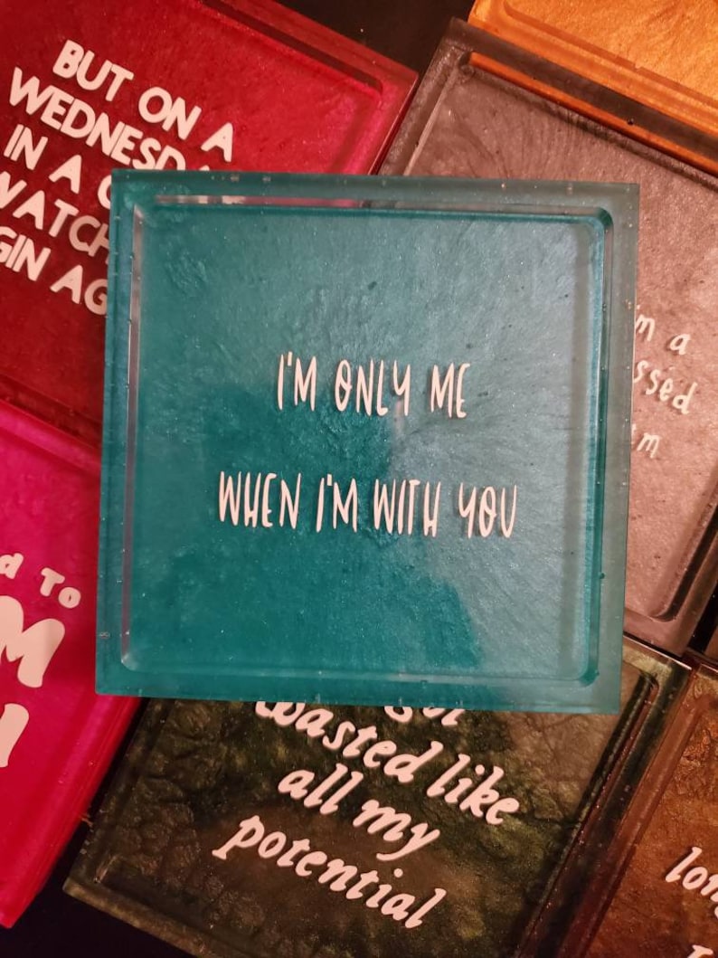 May include: A teal blue square resin coaster with white text that reads "I'm only me when I'm with you".