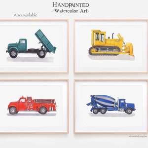 May include: Set of four watercolor prints featuring different construction vehicles. The prints are framed in a light wood frame and feature a green dump truck, a yellow bulldozer, a red fire truck, and a blue cement mixer.