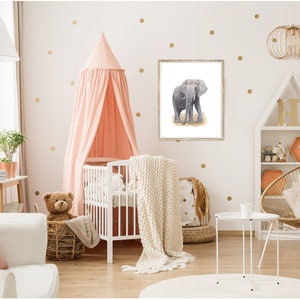 May include: A white crib with a pink canopy and a white blanket. A stuffed teddy bear sits in a wicker basket next to the crib. A framed print of a gray elephant is on the wall behind the crib.