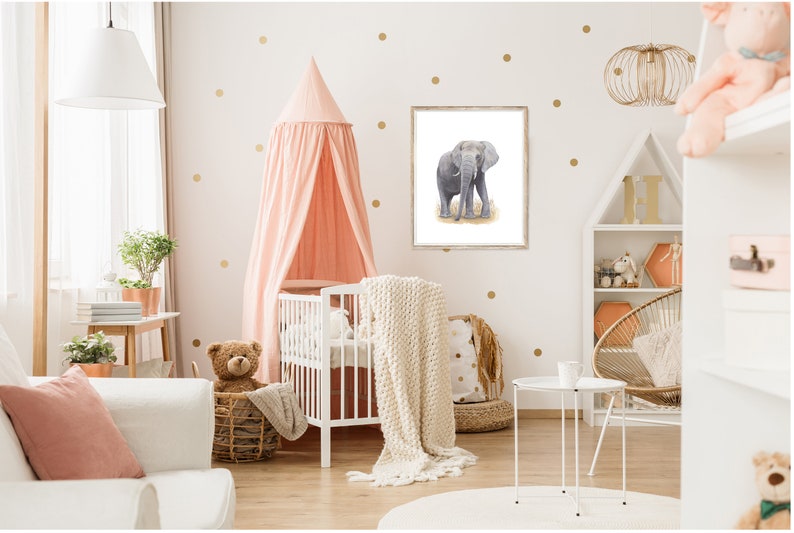 May include: A white crib with a pink canopy and a white blanket. A stuffed teddy bear sits in a wicker basket next to the crib. A framed print of a gray elephant is on the wall behind the crib.