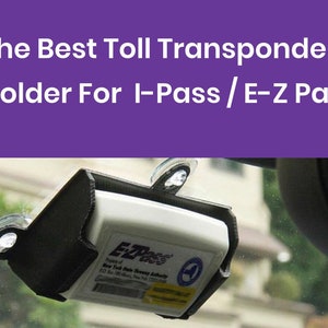 K&ouml;nnte beinhalten: Ein schwarzer Kunststoff-Mauttransponderhalter mit Saugn&auml;pfen zum Befestigen an einer Windschutzscheibe. Der Halter ist f&uuml;r einen E-ZPass-Transponder ausgelegt. Der Transponder ist wei&szlig; mit dem Text "EZPass" und "New York State Thruway Authority" darauf.