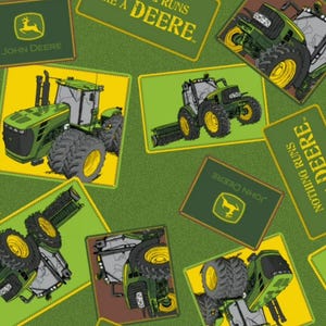 May include: A green fabric pattern featuring John Deere tractors and logos. The design includes rectangular patches with yellow borders, displaying green tractors with large black tires and the text "NOTHING RUNS LIKE A DEERE" in yellow.