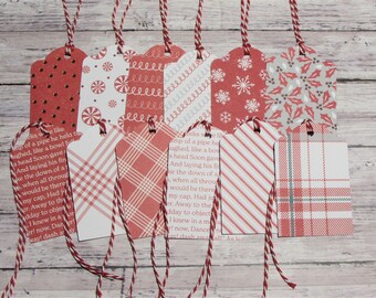May include: Set of ten red and white Christmas gift tags with various patterns, including plaid, polka dots, snowflakes, candy canes, and holly. Each tag has a hole punched at the top and is tied with a red and white twine.