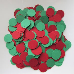 May include: A large pile of red and green paper circles. The circles are all the same size and are arranged in a random pattern.
