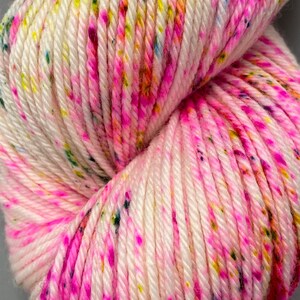 May include: White yarn with pink, yellow, and blue speckles.