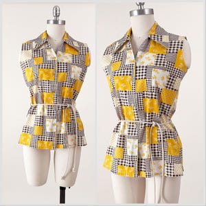May include: A sleeveless yellow and white patchwork shirt with a button-up front and a white belt. The shirt has a checkered and floral pattern.