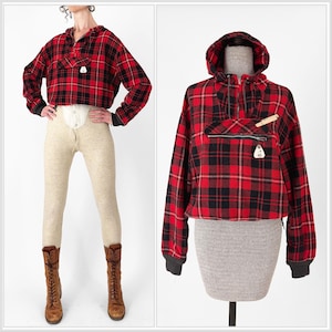 May include: Red and black plaid hooded pullover with a front pocket and zipper. The pullover has long sleeves with black cuffs. The image also shows beige thermal pants and brown lace-up boots.
